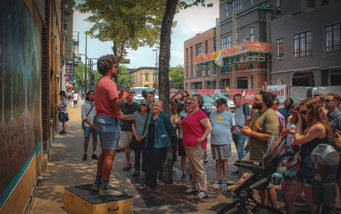 Kiba Freeman talking to crowd in front of the Carbon Cycle mural