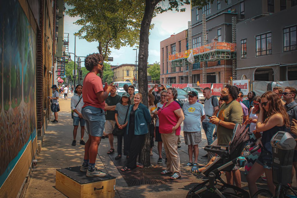 Kiba Freeman talking to crowd in front of the Carbon Cycle mural